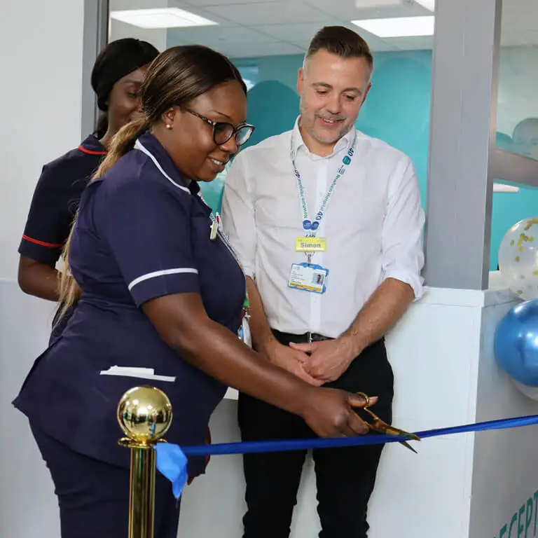 Health professionals cutting a ribbon a t an opening ceremony