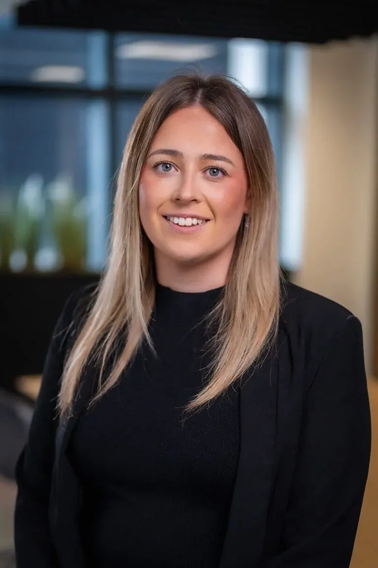 Portrait photo of Lizzie Bentham, Head of Corporate Services stood in an open office