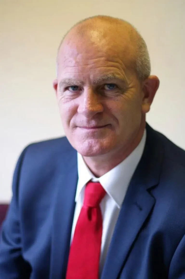 Portrait photo of Mark Raybould, Senior Project Manager stood in an open office